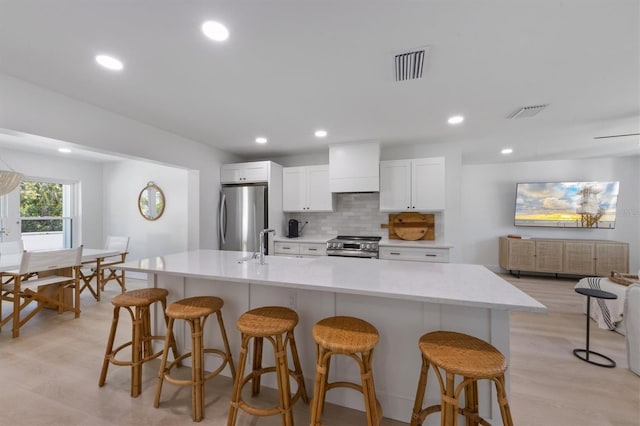 kitchen featuring visible vents, decorative backsplash, white cabinetry, and stainless steel appliances