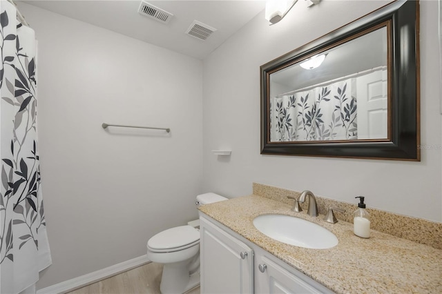 bathroom featuring vanity, toilet, visible vents, and wood finished floors