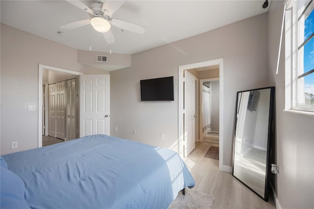 bedroom with visible vents, light wood finished floors, ceiling fan, connected bathroom, and baseboards