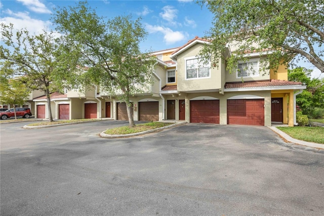 5691 Bentgrass Dr Unit 211, Sarasota, FL 34235 - townhome / multi-family property featuring stucco siding, driveway, a garage, and a tiled roof