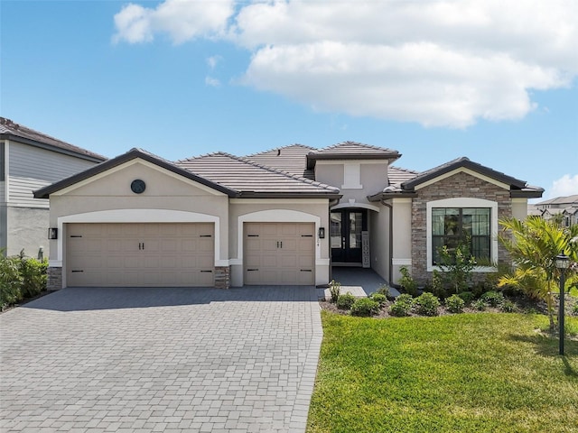 15104 Blue Bay Ter, Lakewood Ranch, FL 34211 - view of front facade with stone siding, stucco siding, decorative driveway, and a garage