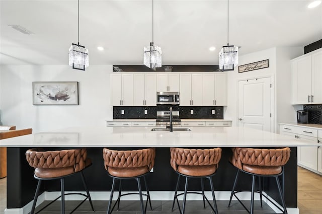 15104 Blue Bay Ter, Lakewood Ranch, FL 34211 - kitchen with appliances with stainless steel finishes, a sink, backsplash, recessed lighting, and light countertops