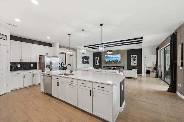15104 Blue Bay Ter, Lakewood Ranch, FL 34211 - kitchen with a sink, stainless steel appliances, an island with sink, light wood-style floors, and recessed lighting