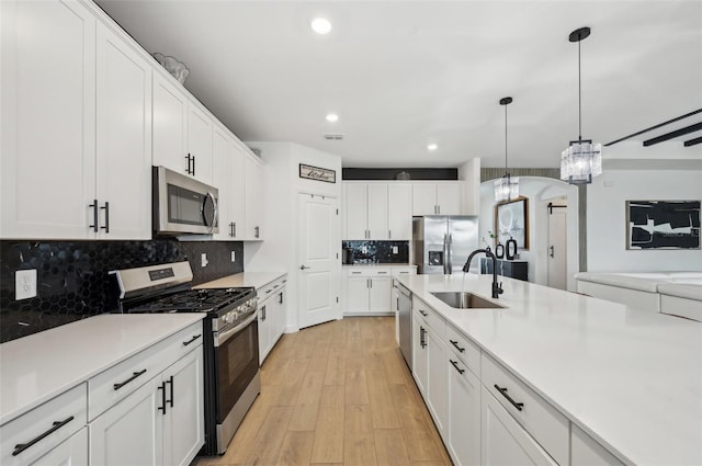 15104 Blue Bay Ter, Lakewood Ranch, FL 34211 - kitchen with appliances with stainless steel finishes, a sink, light wood-style floors, a chandelier, and light countertops