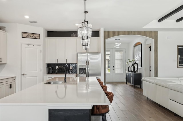 15104 Blue Bay Ter, Lakewood Ranch, FL 34211 - kitchen with stainless steel fridge, a sink, a chandelier, light countertops, and arched walkways