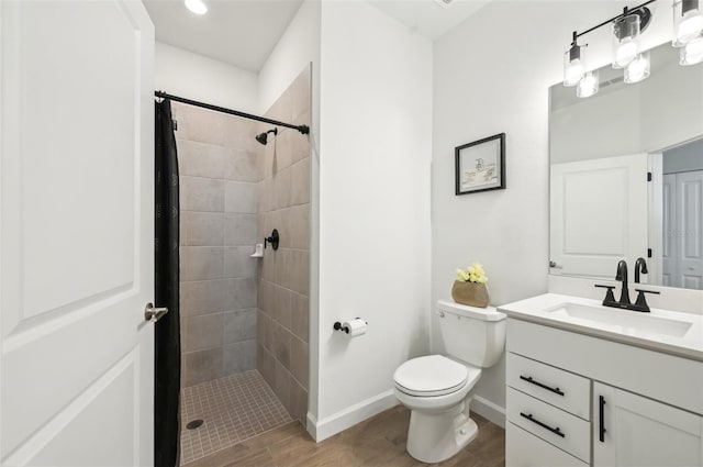 15104 Blue Bay Ter, Lakewood Ranch, FL 34211 - bathroom featuring vanity, toilet, a tile shower, and wood finished floors