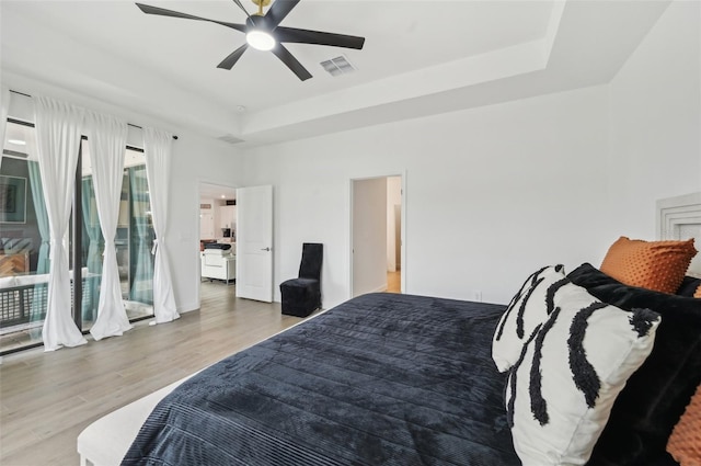 15104 Blue Bay Ter, Lakewood Ranch, FL 34211 - bedroom featuring a raised ceiling, wood finished floors, a ceiling fan, and access to exterior