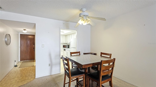 3763 Lake Bayshore Dr Unit 310, Bradenton, FL 34205 - dining space featuring light carpet, a textured ceiling, baseboards, and a ceiling fan