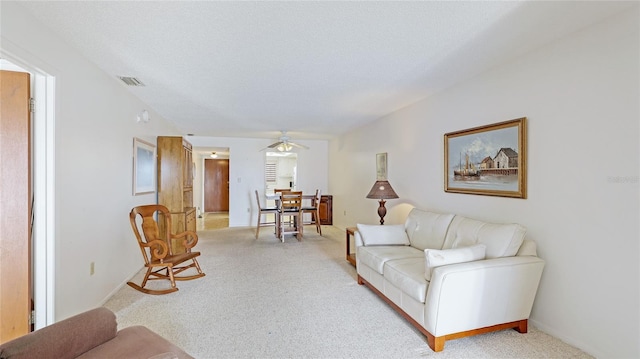 3763 Lake Bayshore Dr Unit 310, Bradenton, FL 34205 - living room featuring a ceiling fan, light carpet, a textured ceiling, baseboards, and visible vents
