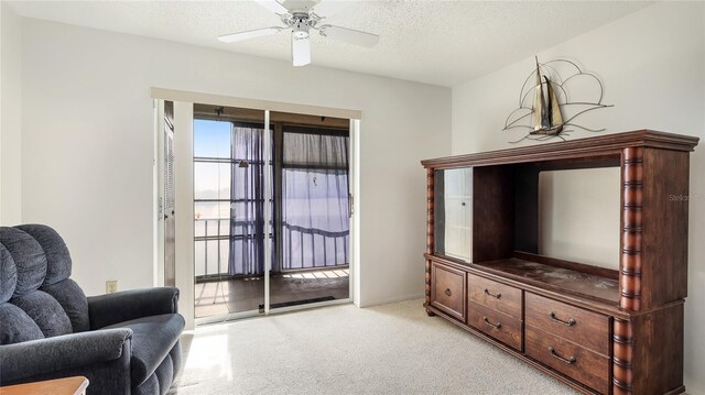3763 Lake Bayshore Dr Unit 310, Bradenton, FL 34205 - living area with a textured ceiling, a ceiling fan, and light colored carpet