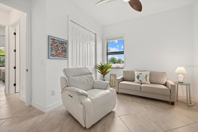 sitting room featuring a ceiling fan, healthy amount of natural light, baseboards, and light tile patterned floors