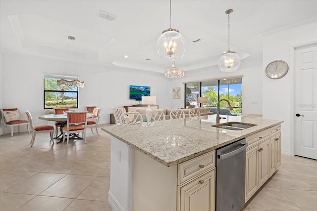 kitchen with stainless steel dishwasher, cream cabinetry, a sink, light tile patterned floors, and healthy amount of natural light