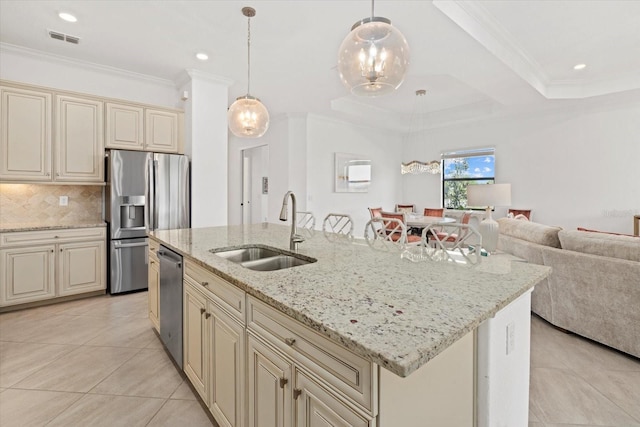 kitchen featuring cream cabinets, a sink, appliances with stainless steel finishes, light tile patterned floors, and crown molding
