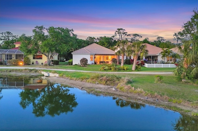exterior space with a water view and a lawn