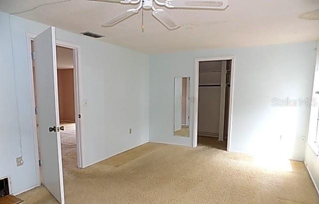 6309 35th Ave W, Bradenton, FL 34209 - unfurnished bedroom featuring ceiling fan, a closet, light colored carpet, and visible vents