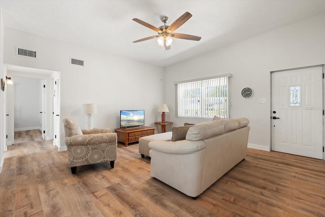 living room featuring baseboards, visible vents, a ceiling fan, and wood finished floors