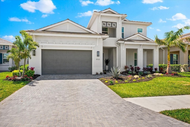 8163 Redonda Loop, Lakewood Ranch, FL 34202 - view of front facade featuring stucco siding, decorative driveway, a front lawn, and an attached garage