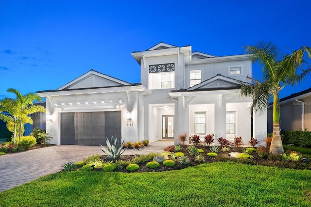 8163 Redonda Loop, Lakewood Ranch, FL 34202 - view of front facade featuring decorative driveway, stucco siding, a garage, and a front lawn