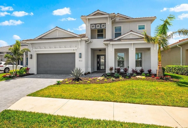 8163 Redonda Loop, Lakewood Ranch, FL 34202 - view of front of home featuring stucco siding, decorative driveway, an attached garage, and a front lawn