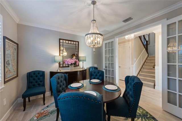dining area featuring stairway, a notable chandelier, visible vents, and wood finished floors