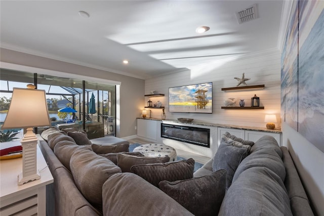living area featuring visible vents, baseboards, bar area, ornamental molding, and recessed lighting