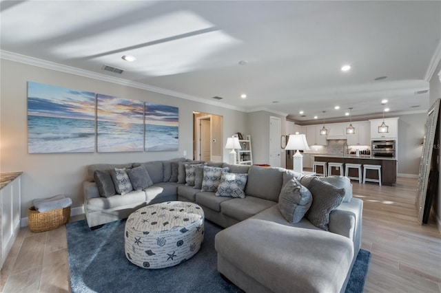 living area with light wood finished floors, baseboards, ornamental molding, and recessed lighting