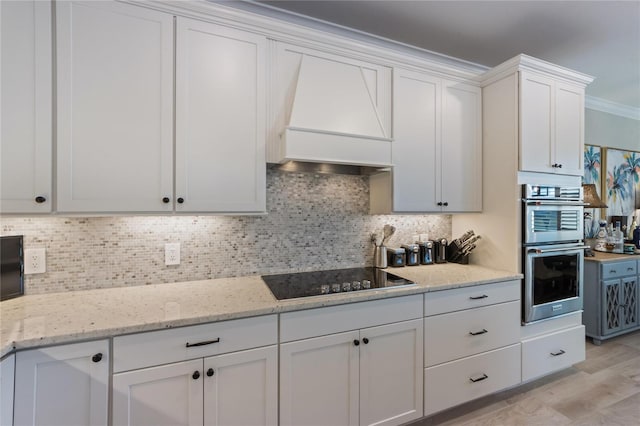 kitchen featuring tasteful backsplash, double oven, black electric stovetop, and white cabinets