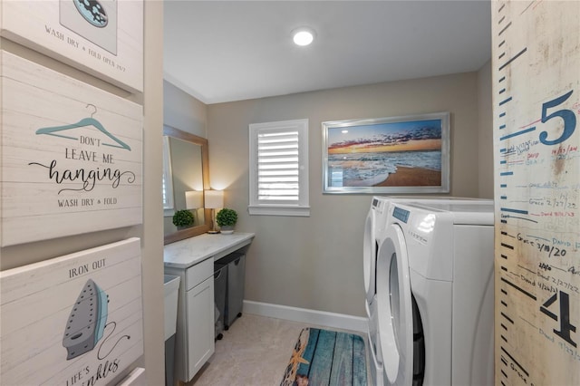 laundry area with separate washer and dryer, cabinet space, and baseboards