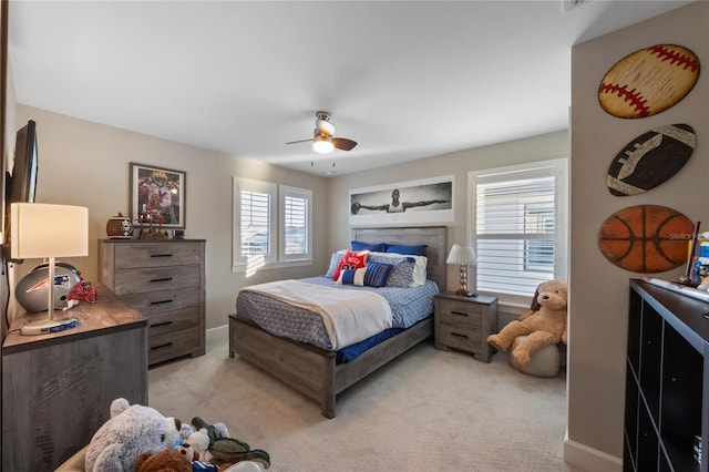 bedroom with ceiling fan, light carpet, and baseboards