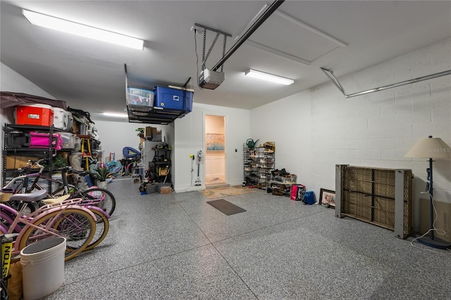garage with concrete block wall and a garage door opener
