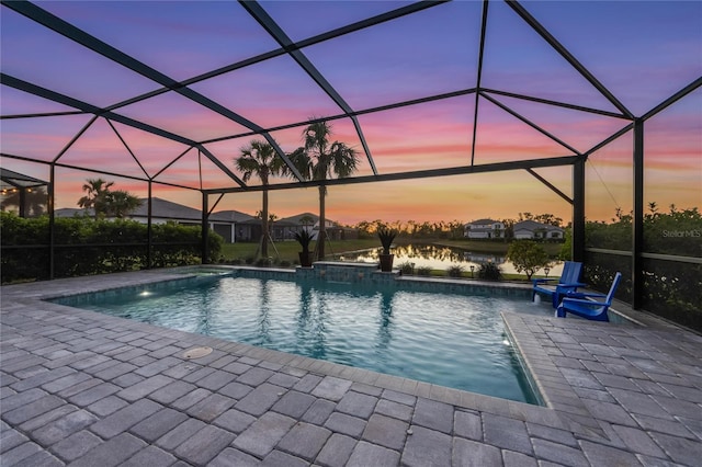 outdoor pool featuring glass enclosure and a patio