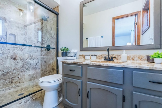 bathroom with toilet, vanity, and a stall shower