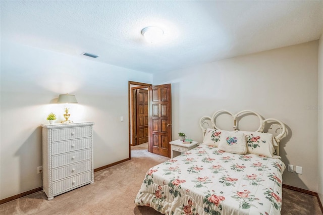 bedroom featuring light carpet, visible vents, baseboards, and a textured ceiling