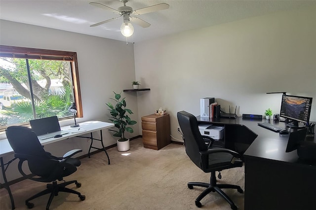 office featuring light carpet, ceiling fan, and baseboards
