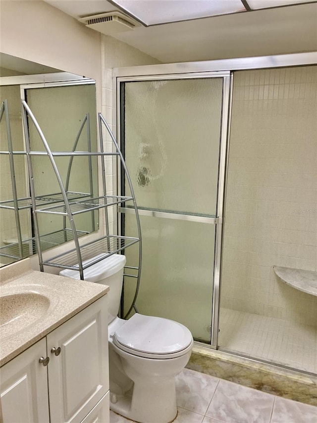 bathroom featuring vanity, toilet, tile patterned floors, a stall shower, and visible vents