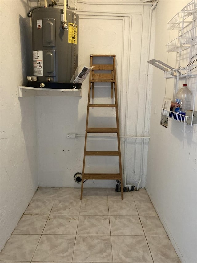 basement featuring water heater and tile patterned floors