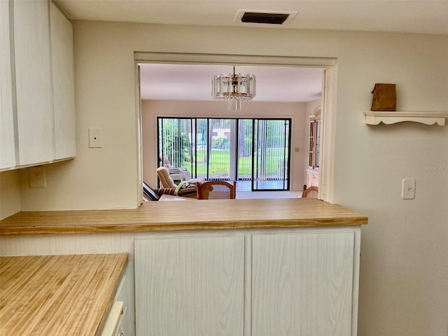 kitchen featuring visible vents, light countertops, white cabinetry, and a chandelier