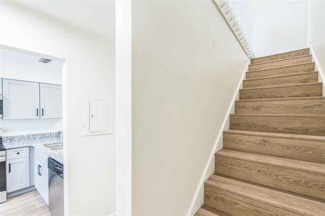 1236 Dovehill Dr, Apopka, FL 32703 - stairway featuring electric panel, wood finished floors, and bar