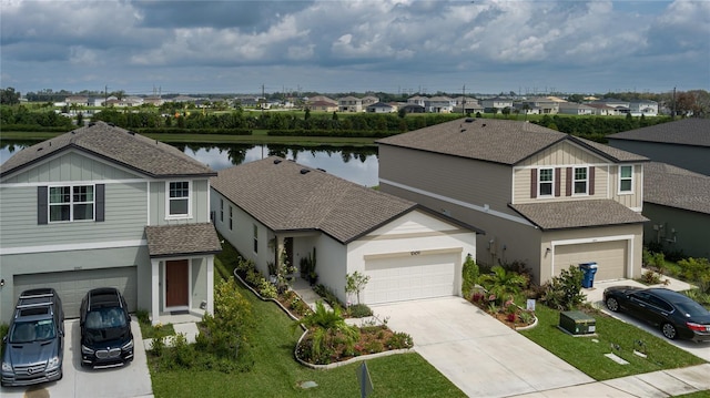 traditional home with driveway, stucco siding, a residential view, and a water view
