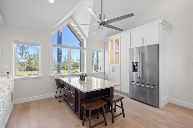 71 Tidy Island Blvd, Bradenton, FL 34210 - kitchen featuring a kitchen bar, vaulted ceiling, white cabinets, light stone countertops, and high quality fridge