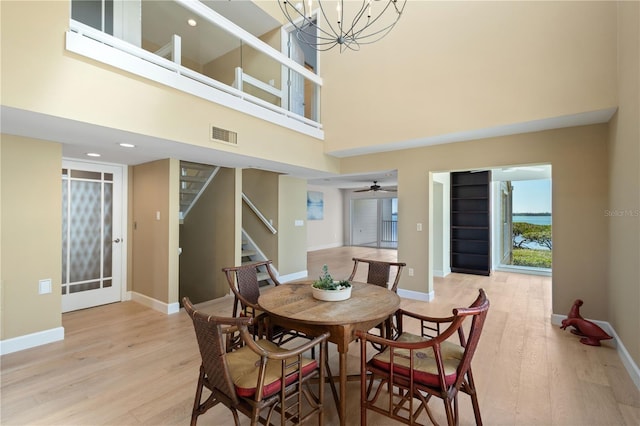 71 Tidy Island Blvd, Bradenton, FL 34210 - dining area featuring stairs, ceiling fan with notable chandelier, baseboards, light wood finished floors, and visible vents