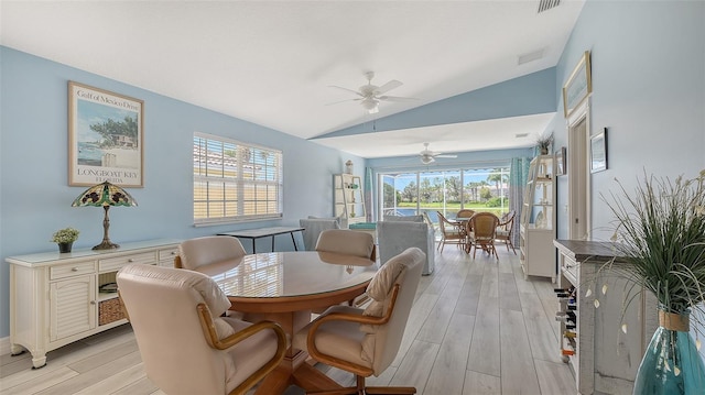 dining area with light wood finished floors, visible vents, ceiling fan, and vaulted ceiling