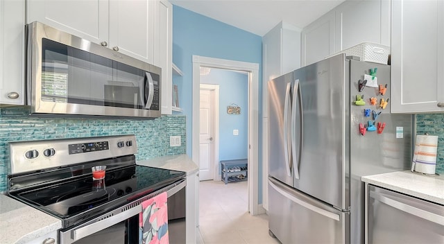 kitchen with backsplash, light countertops, white cabinetry, and stainless steel appliances