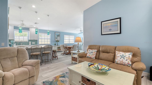 living room featuring visible vents, ceiling fan, light wood-type flooring, and recessed lighting
