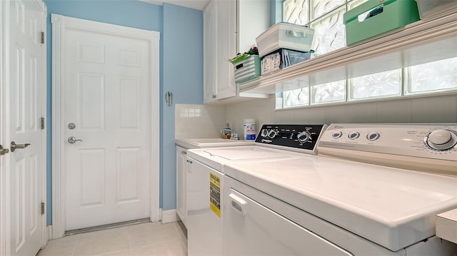 clothes washing area featuring light tile patterned floors, baseboards, a sink, cabinet space, and washer and clothes dryer