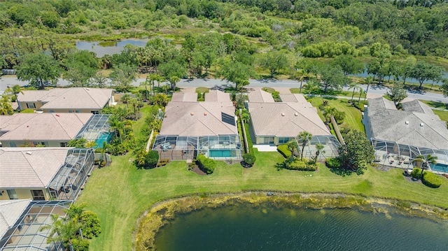 birds eye view of property featuring a water view, a residential view, and a forest view