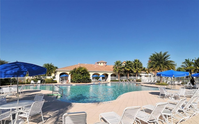community pool with a patio and fence