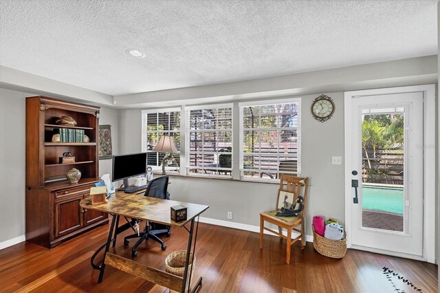 office space with dark wood-style floors, baseboards, and a healthy amount of sunlight