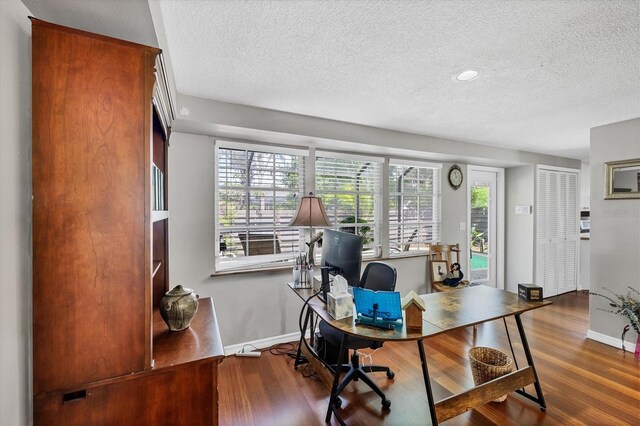 office with baseboards, wood finished floors, and a textured ceiling