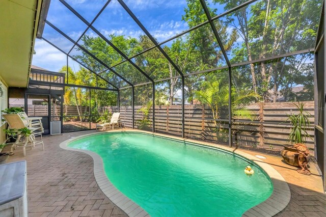 view of swimming pool featuring a fenced backyard, a lanai, a patio, and a fenced in pool